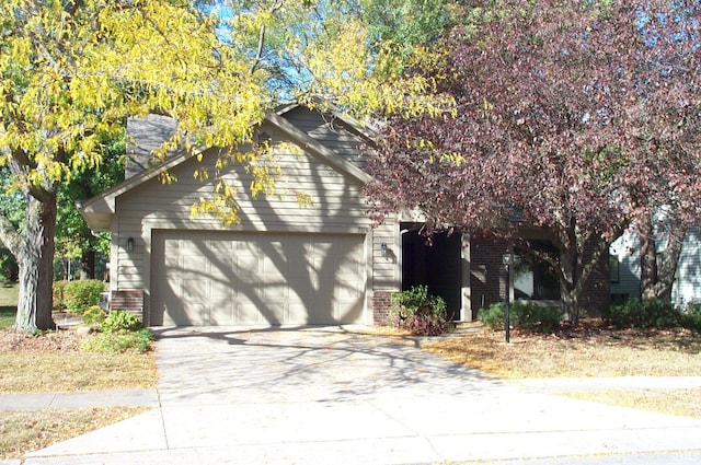 view of property hidden behind natural elements featuring a garage