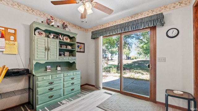 doorway to outside with light wood finished floors, visible vents, baseboards, and ceiling fan