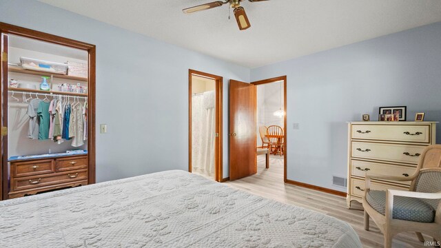 bedroom featuring light wood-style flooring, a closet, a ceiling fan, visible vents, and baseboards