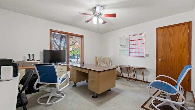 office area with light carpet, ceiling fan, baseboards, and a textured ceiling