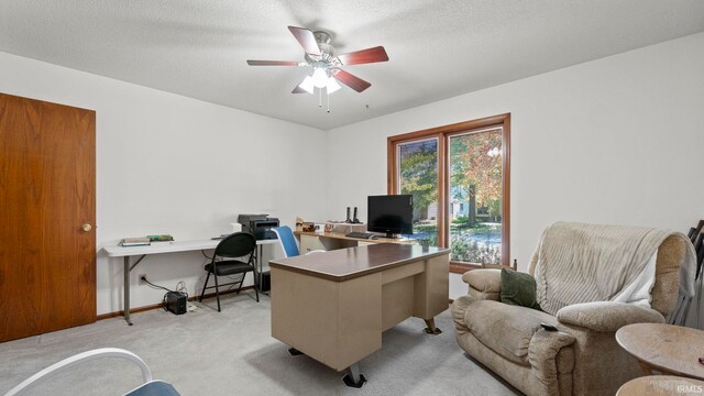 home office with ceiling fan, a textured ceiling, and light carpet