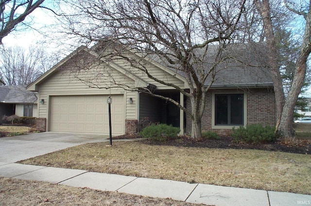obstructed view of property with brick siding, driveway, and an attached garage