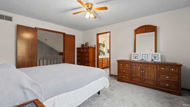 carpeted bedroom with ensuite bathroom, ceiling fan, and lofted ceiling