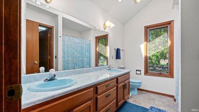 bathroom featuring vaulted ceiling, toilet, and vanity