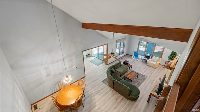 living room featuring wood finished floors, high vaulted ceiling, and baseboards