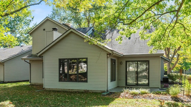 rear view of house featuring a lawn