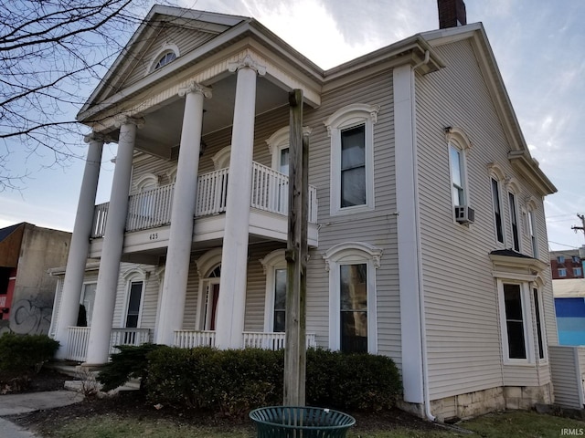 view of property exterior featuring cooling unit, a balcony, and covered porch