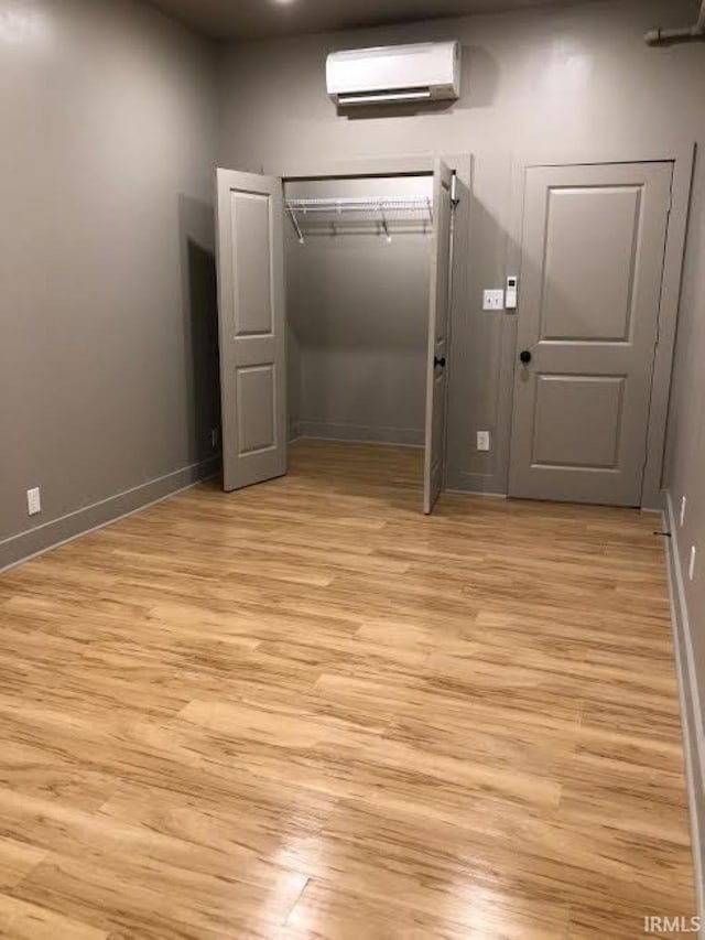 interior space featuring light hardwood / wood-style flooring and a wall unit AC