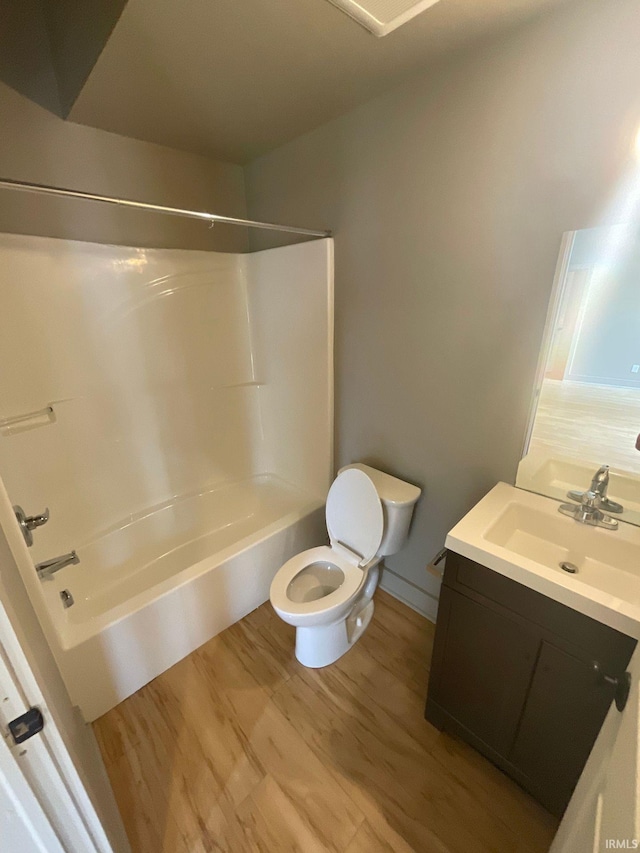 full bathroom with vanity, hardwood / wood-style flooring, toilet, and tub / shower combination