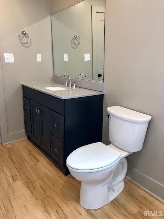 bathroom featuring vanity, hardwood / wood-style floors, and toilet