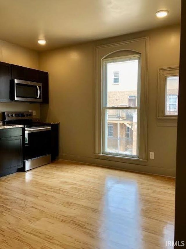 kitchen with appliances with stainless steel finishes and light hardwood / wood-style floors