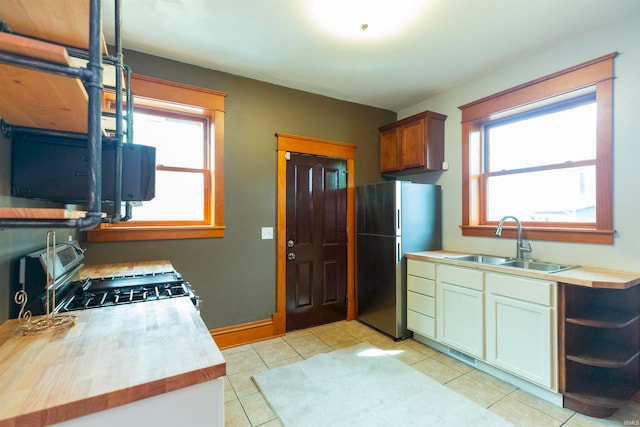 kitchen featuring range with gas stovetop, stainless steel refrigerator, sink, and a healthy amount of sunlight