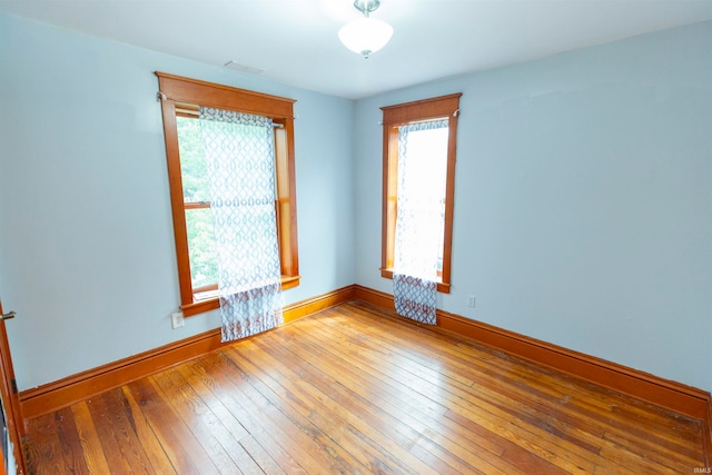 unfurnished room with hardwood / wood-style flooring