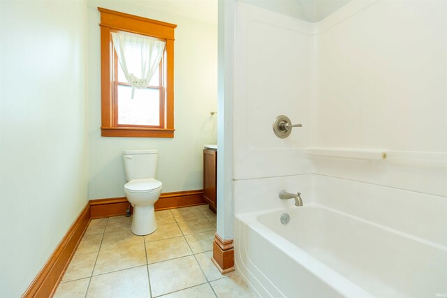 bathroom with tile patterned flooring, a bath, vanity, and toilet