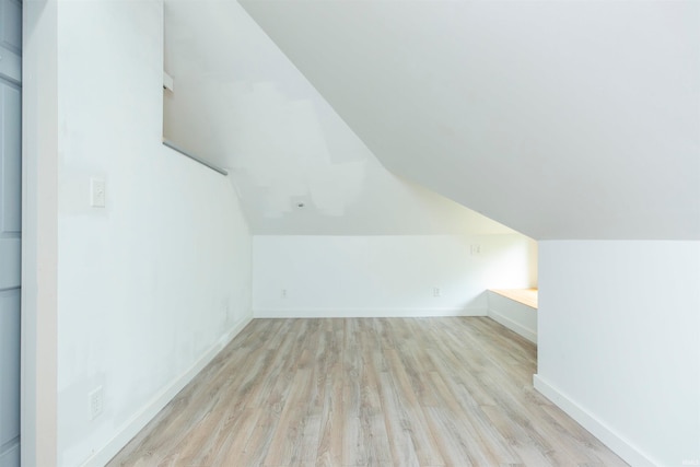 bonus room with light hardwood / wood-style floors and vaulted ceiling