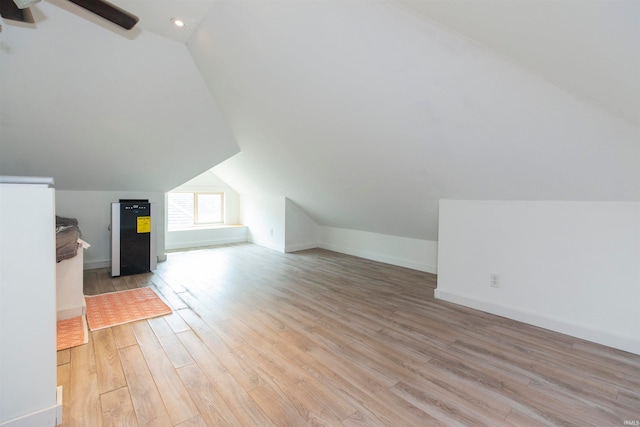 additional living space with light hardwood / wood-style floors and vaulted ceiling