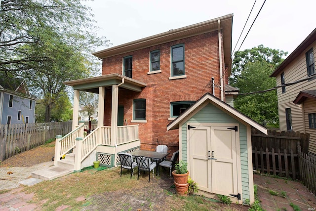 rear view of house featuring a storage unit