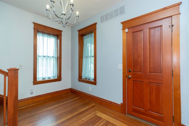 entrance foyer featuring hardwood / wood-style floors and an inviting chandelier