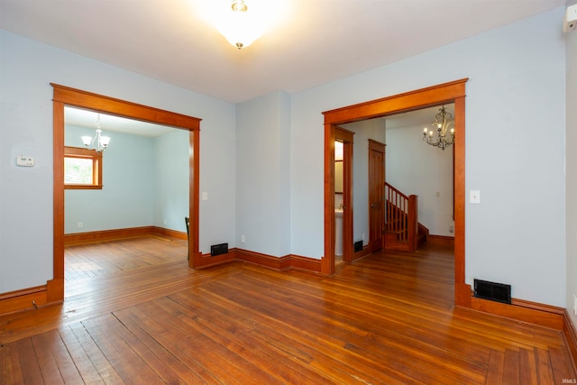 unfurnished room featuring hardwood / wood-style floors and a chandelier