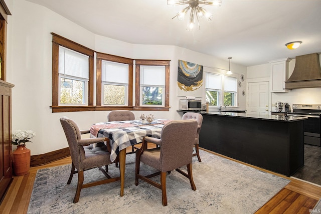 dining area with an inviting chandelier and dark wood-type flooring