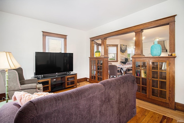 living room featuring ornate columns and wood-type flooring