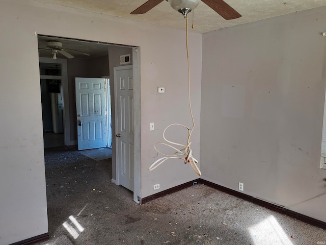 carpeted spare room with ceiling fan and a textured ceiling