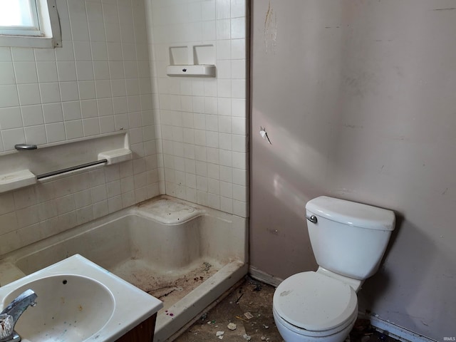 bathroom with tiled shower, vanity, and toilet