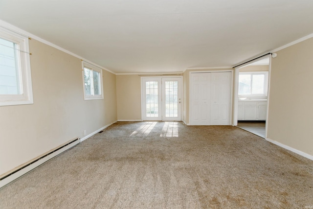 carpeted spare room with ornamental molding and a baseboard heating unit