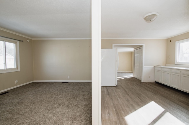 unfurnished living room with light hardwood / wood-style flooring and crown molding