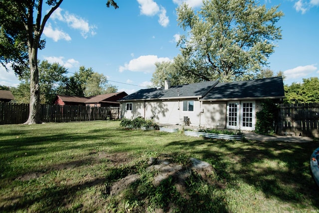 rear view of house featuring a yard and french doors