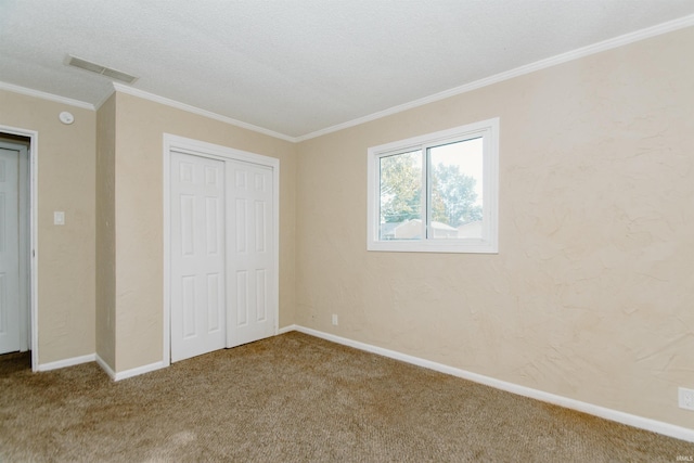 unfurnished bedroom with carpet flooring, crown molding, and a closet