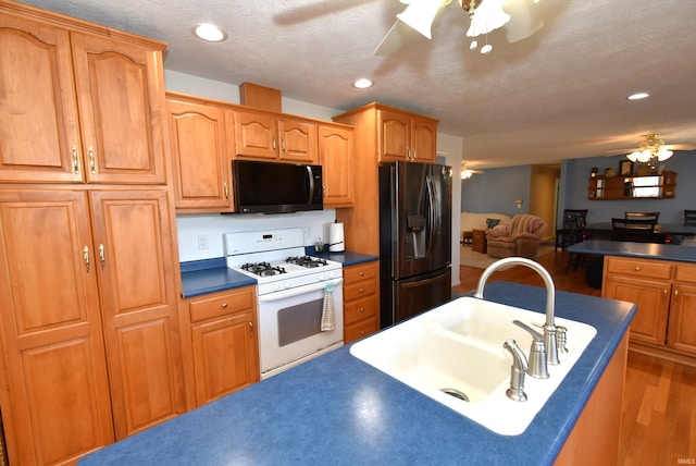 kitchen with ceiling fan, white range with gas cooktop, sink, stainless steel fridge with ice dispenser, and a textured ceiling