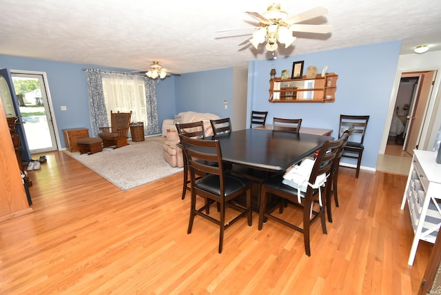 dining area featuring a textured ceiling, ceiling fan, and light hardwood / wood-style flooring