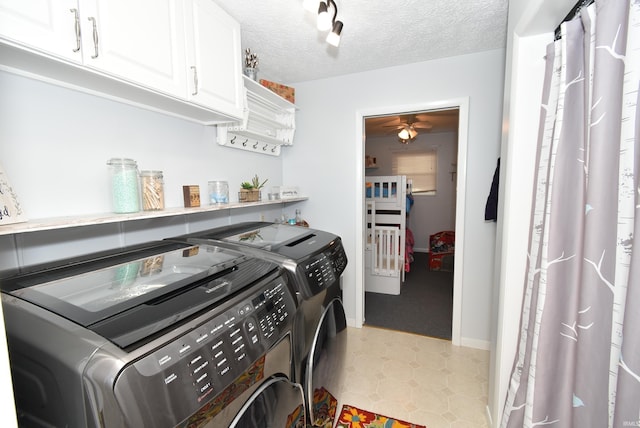 washroom with ceiling fan, cabinets, independent washer and dryer, and a textured ceiling