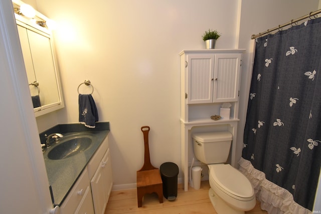 bathroom featuring hardwood / wood-style floors, toilet, vanity, and a shower with curtain