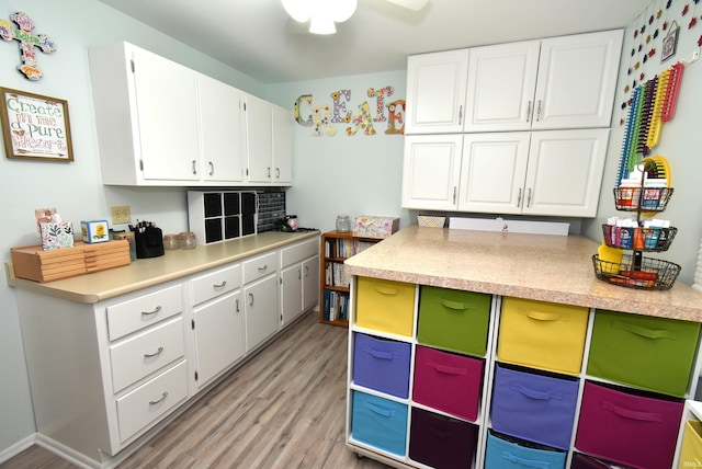 kitchen with white cabinetry and light hardwood / wood-style flooring