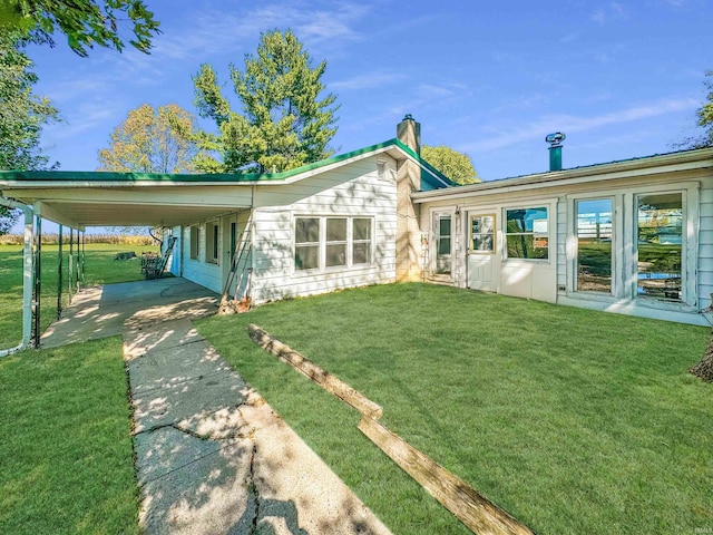 back of house featuring a carport and a lawn