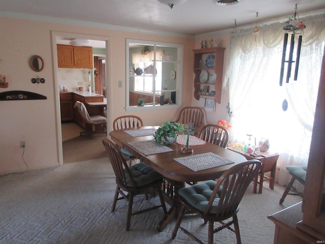 dining room featuring light carpet and crown molding