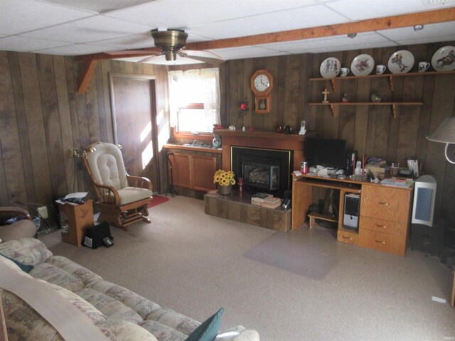 living room featuring wood walls, carpet floors, a paneled ceiling, and ceiling fan