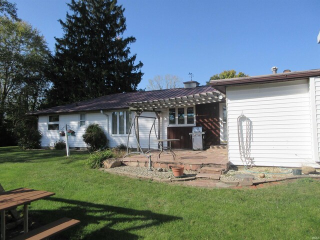 back of property featuring a yard, a patio area, and a pergola