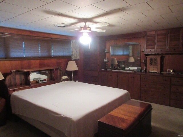 bedroom featuring wood walls and ceiling fan