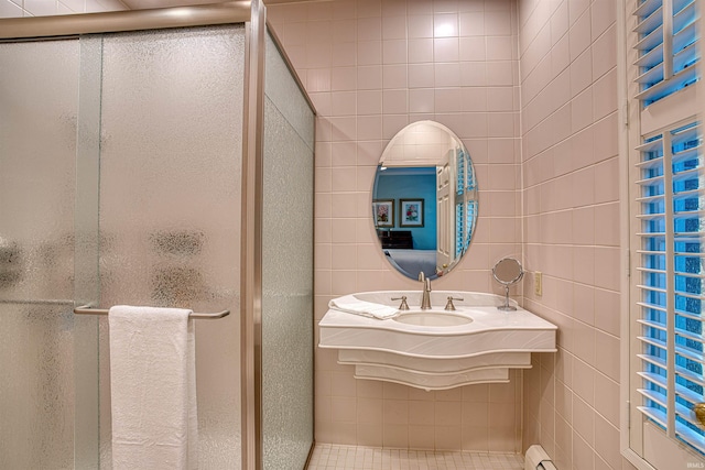 bathroom with sink, walk in shower, and tile walls