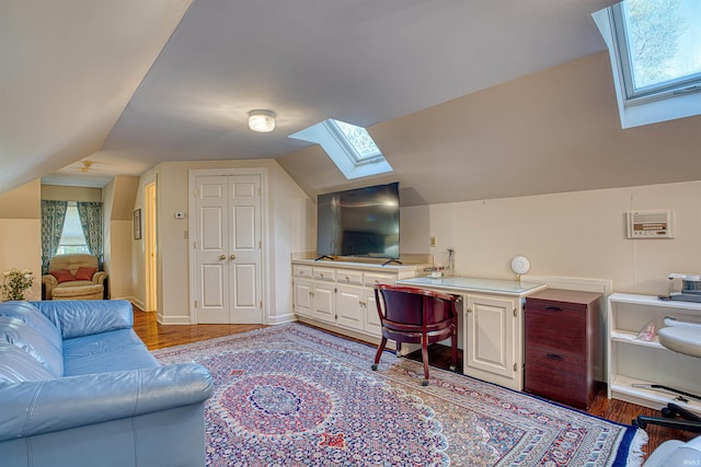 home office with lofted ceiling, light hardwood / wood-style floors, and a healthy amount of sunlight