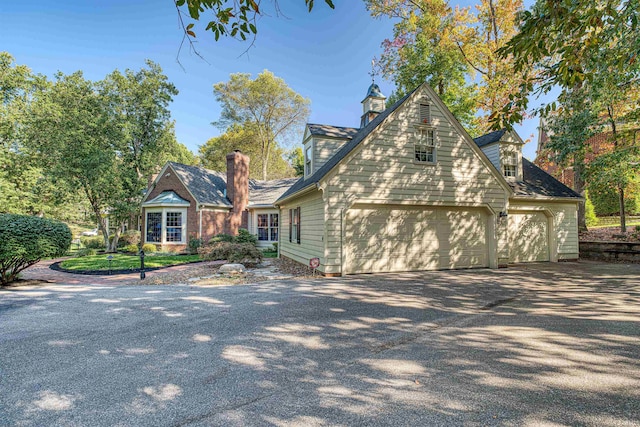 cape cod-style house featuring a garage