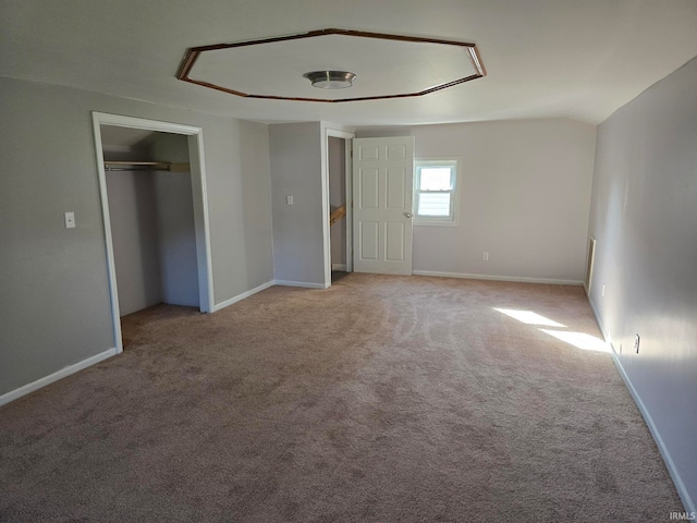 unfurnished bedroom featuring light carpet and lofted ceiling