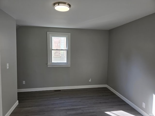 spare room with dark hardwood / wood-style flooring