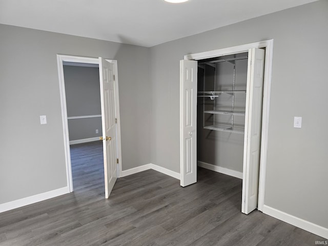 unfurnished bedroom featuring dark wood-type flooring and a closet