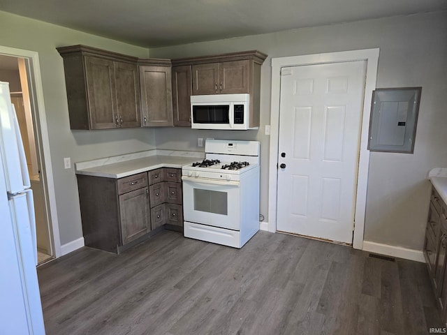 kitchen with dark brown cabinets, electric panel, light hardwood / wood-style floors, and white appliances