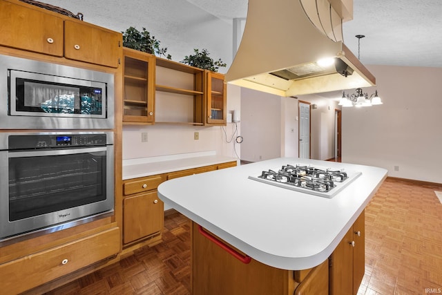 kitchen featuring appliances with stainless steel finishes, hanging light fixtures, a center island, and a textured ceiling