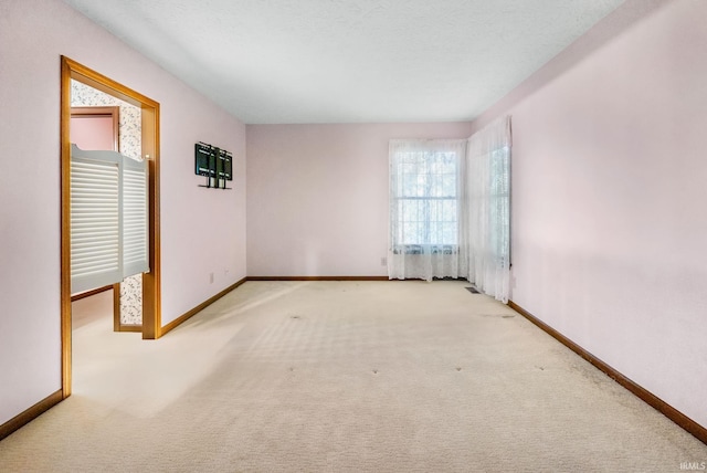 carpeted empty room with a textured ceiling